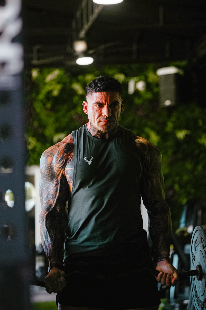 “Focused athlete wearing Bucked Up sleeveless performance shirt during intense gym workout – fitness apparel and strength training lifestyle.”